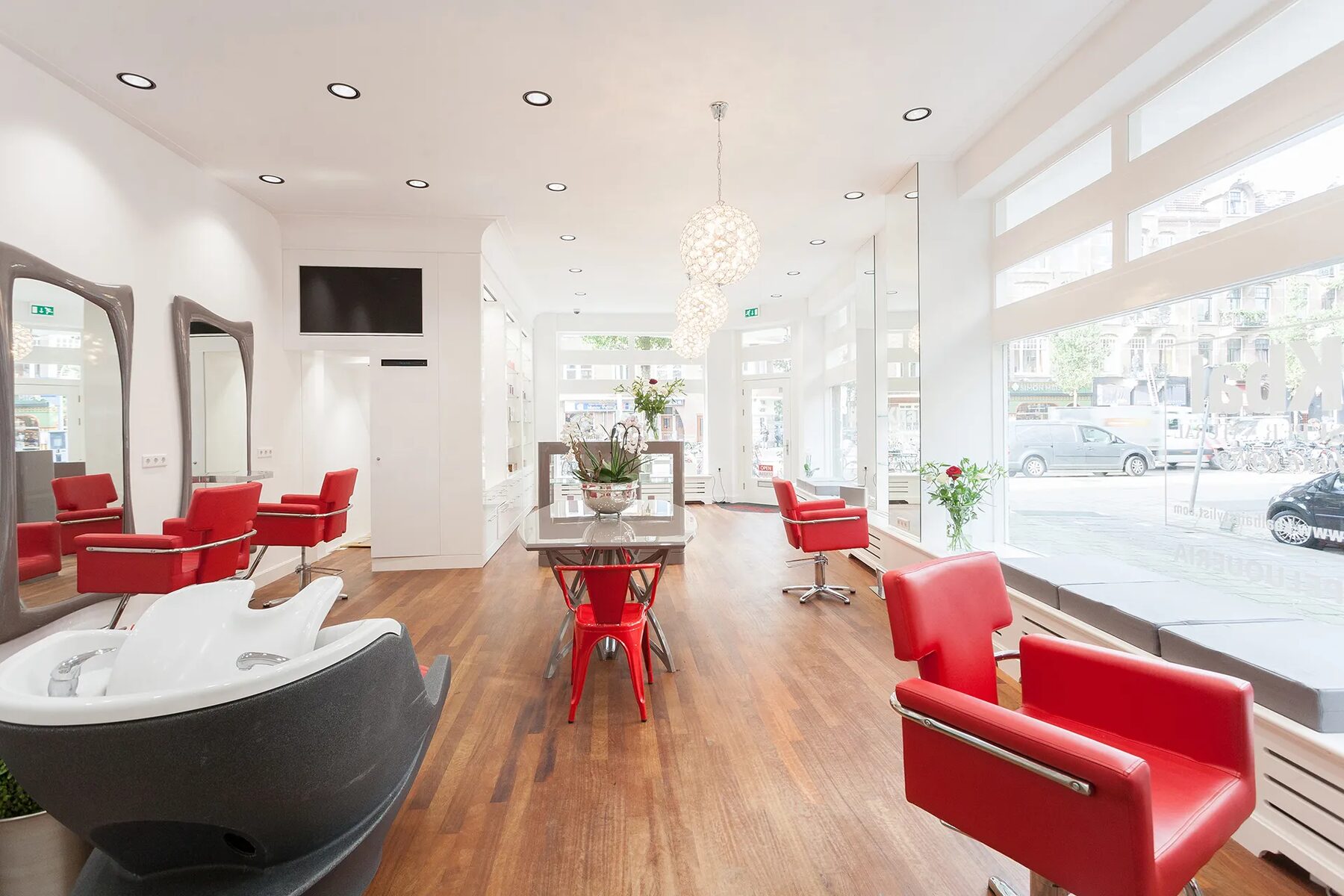 Lichte salon met rode accenten en houten vloer